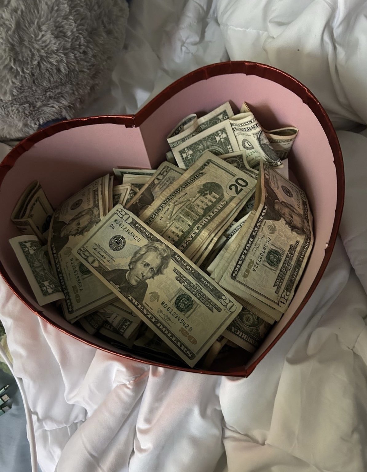 Caja de bombones llena de billetes, representación visual del finfet y la seducción del dinero en la dominación financiera